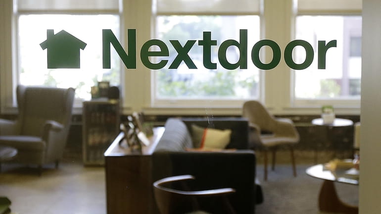 A Nextdoor sign is shown in a window at an...