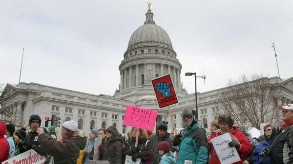 Protesters demonstrate outside the Wisconsin State Capitol during a rally...