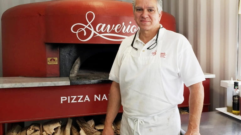 Saverio "Sam" Cataldo stands in front of the back-patio pizza...