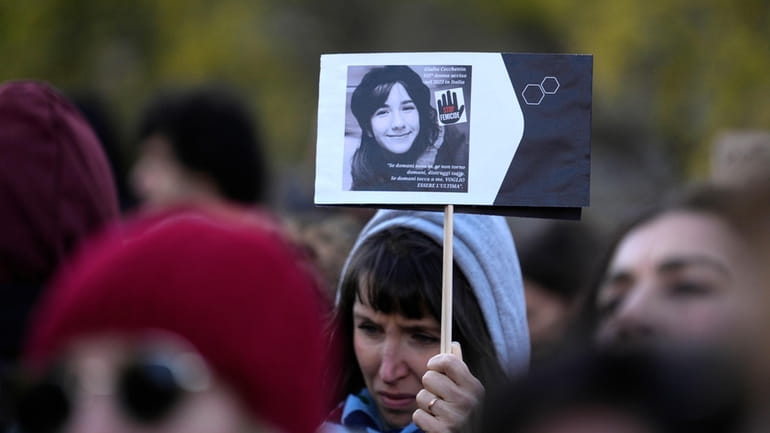 A woman shows a photo of Giulia Cecchettin, allegedly killed...