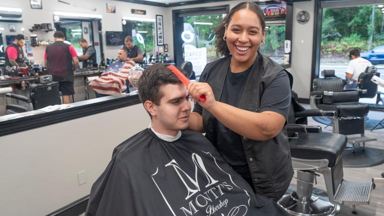 Victoria Pettas, 18, of Moriches practices her barber skills on...