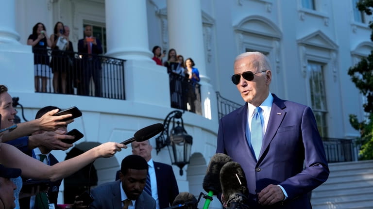 President Joe Biden talks with reporters on the South Lawn...