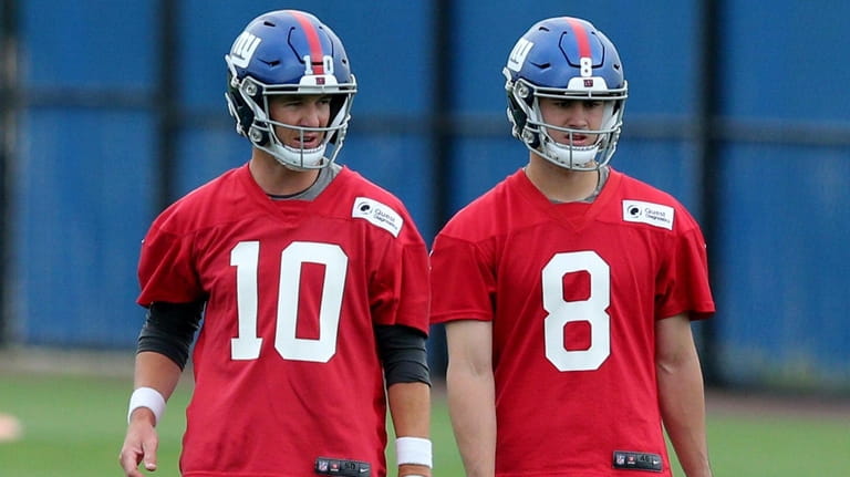 Giants quarterbacks Eli Manning, left, and Daniel Jones talk during OTAs at...