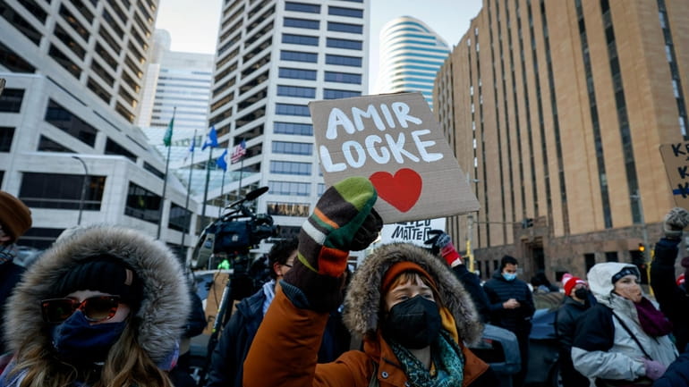 A protester holds a sign with Amir Locke's name on...