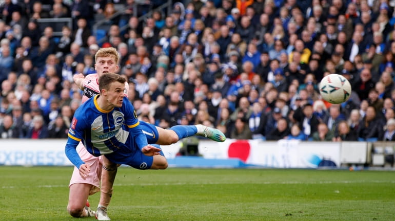 Brighton's Solly March, foreground, scores his side's fourth goal with...