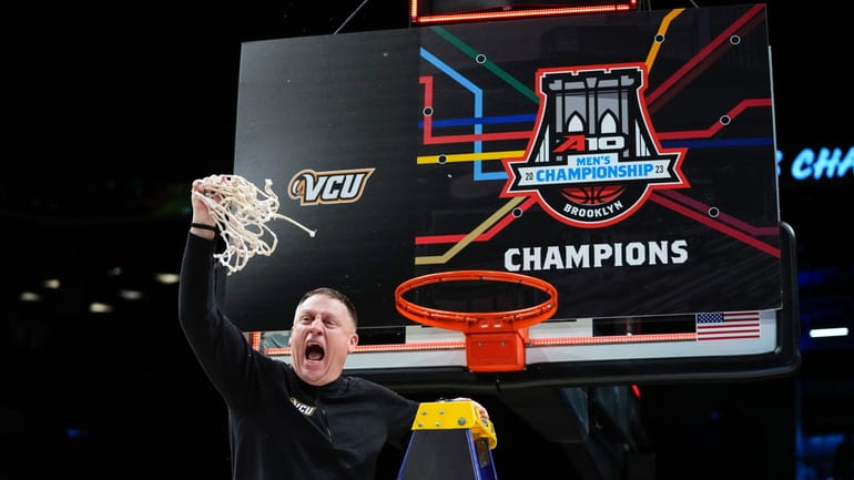Virginia Commonwealth head coach Mike Rhoades celebrates after cutting down...