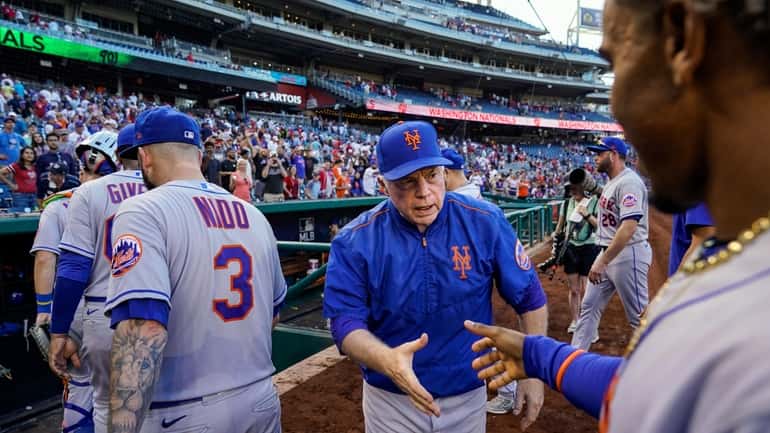 New York Mets manager Buck Showalter, center, reaches to shake...