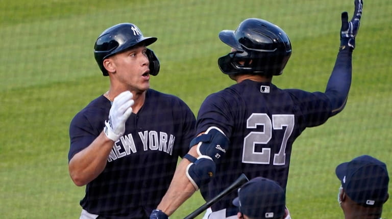 New York Yankees' Aaron Judge, left, celebrates with Giancarlo Stanton...