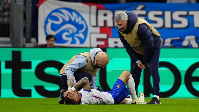 France's Jonathan Clauss receives medical attention during an international friendly...