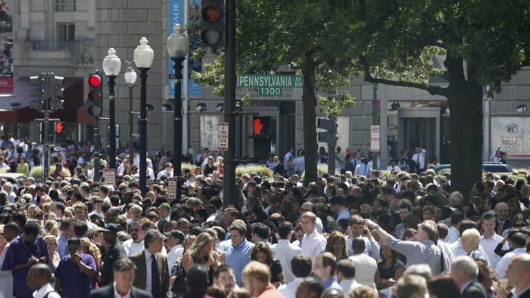 People crowd Pennsylvania Avenue as they evacuate buildings after an...
