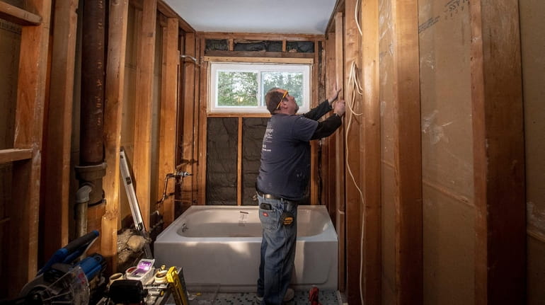 Hogan Construction's Jim Fitzgerald prepairs a wood frame to put...