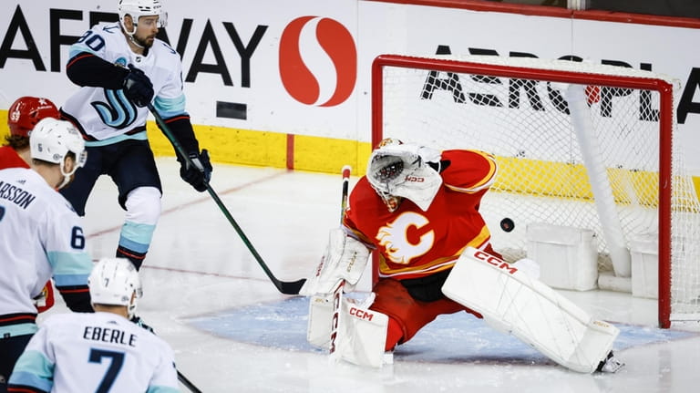 Seattle Kraken defenseman Adam Larsson (6) scoresagainst Calgary Flames goalie...