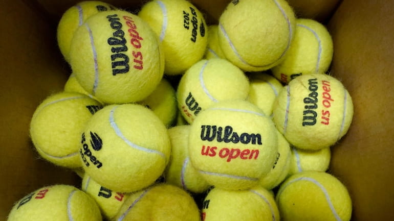 A box of game-used tennis balls rest in a shipping...