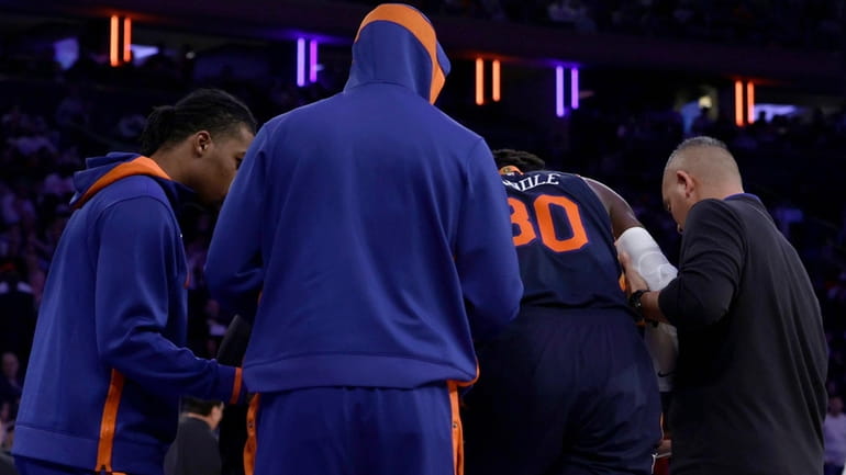 Julius Randle of the Knicks is helped off the court...