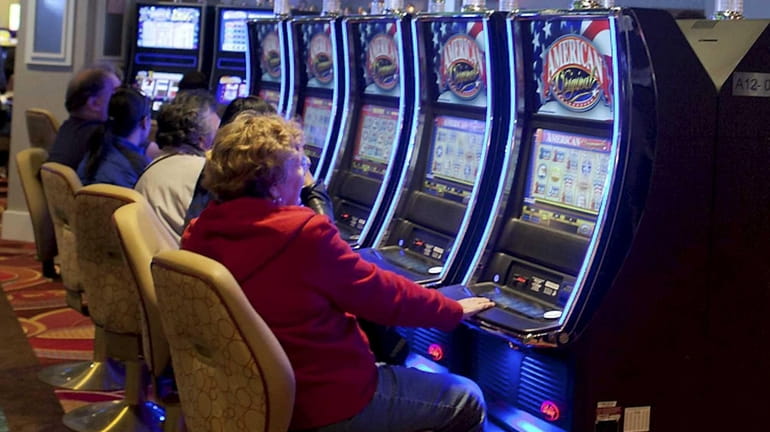 Guests play slot machines at the new Resorts World Casino-New...