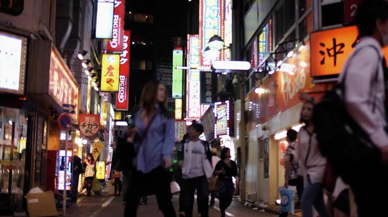 The brightly lit streets of Tokyo in a scene from...