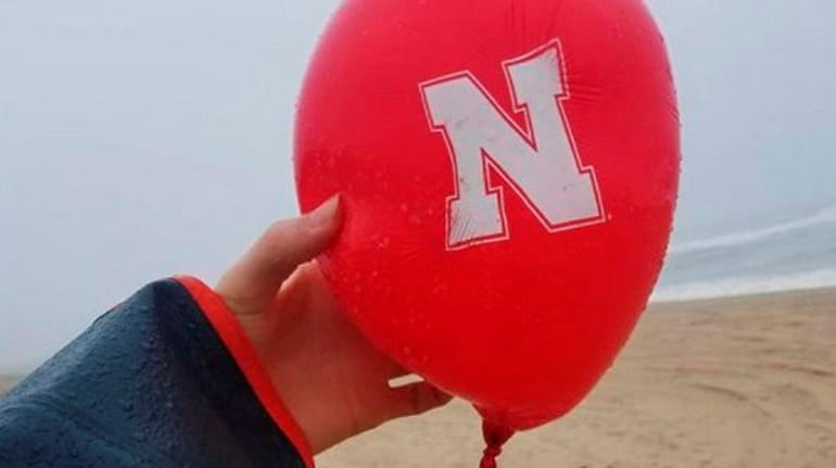 Alyssa Lefebvre of Port Washington holds the University of Nebraska balloon she...