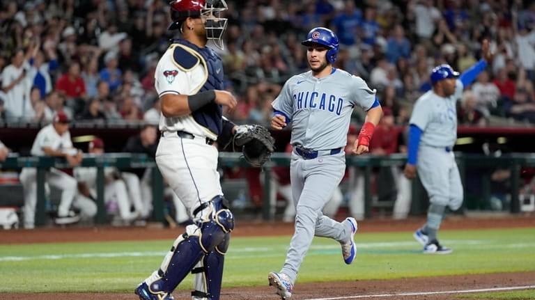 Chicago Cubs' Nick Madrigal, right, scores on a base hit...