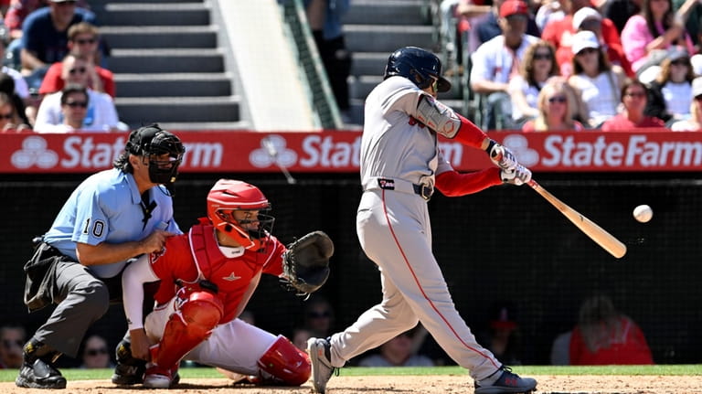 Boston Red Sox's Masataka Yoshida, right, hits an RBI single...