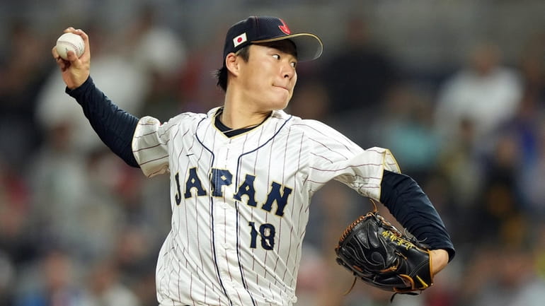 Yoshinobu Yamamoto (18) of Team Japan pitches in the eighth...
