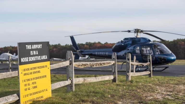 A helicopter sits on the tarmac at the East Hampton...