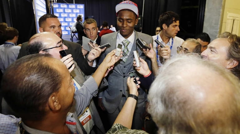 St. John's Maurice Harkless, center, talks to reporters after being...