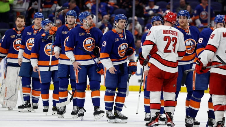 The Islanders shake hands with the Carolina Hurricanes after losing Game...