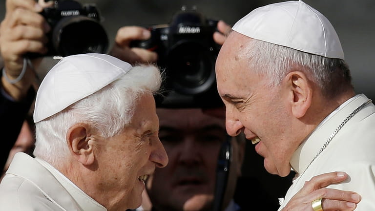 Pope Francis, right, hugs Emeritus Pope Benedict XVI prior to...