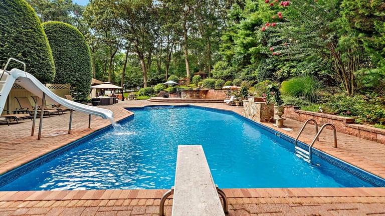 The backyard has an in-ground pool, hot tub and outdoor...