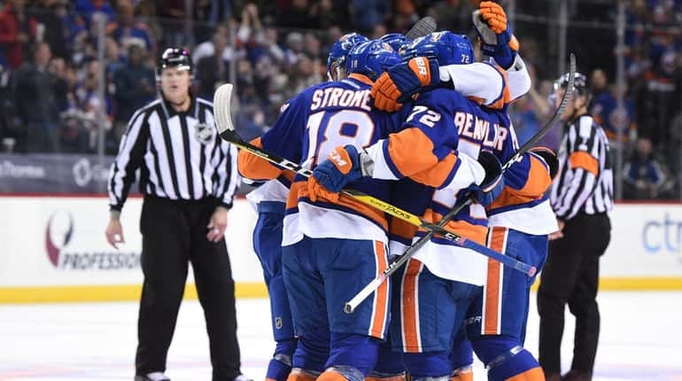 New York Islanders players celebrate a goal by Islanders defenseman...