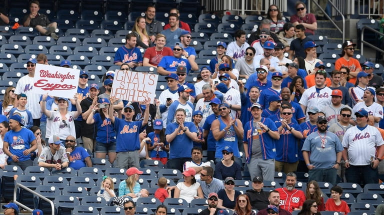 Mets fans hold up signs during a game against the...