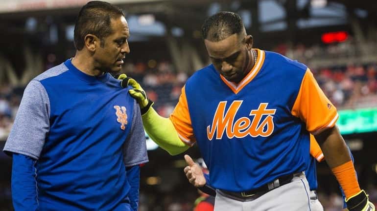 Yoenis Cespedes of the Mets is helped off the field...