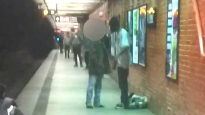A surveillance video shows two men on a subway platform...