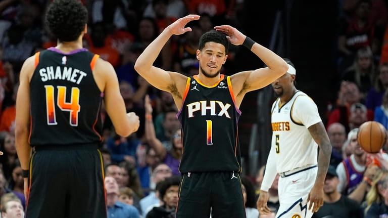Phoenix Suns guard Devin Booker (1) reacts to a turn...