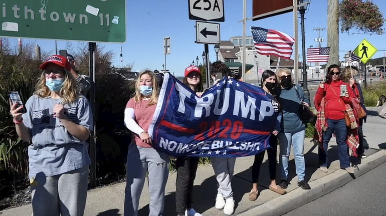 Trump supporters greet a truck and car parade through Port...