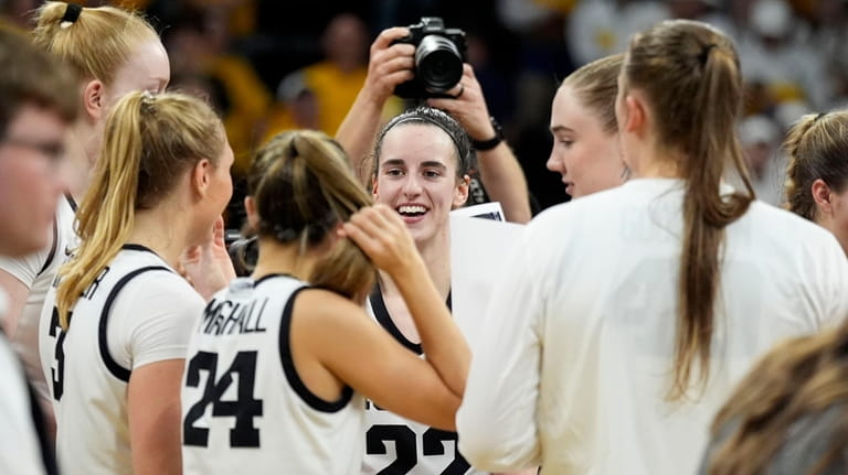 Iowa guard Caitlin Clark (22) celebrates with teammates after a...