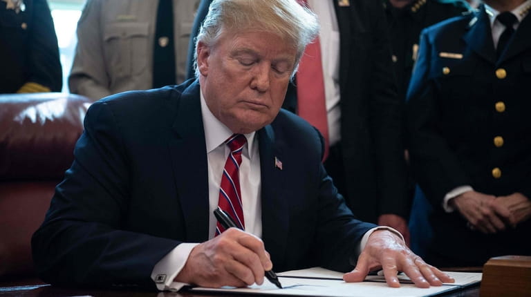 President Donald Trump signs the first veto of his presidency,...