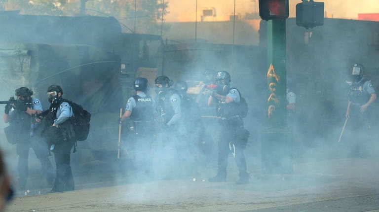 Police shoot tear gas during protests in Minneapolis on Friday...