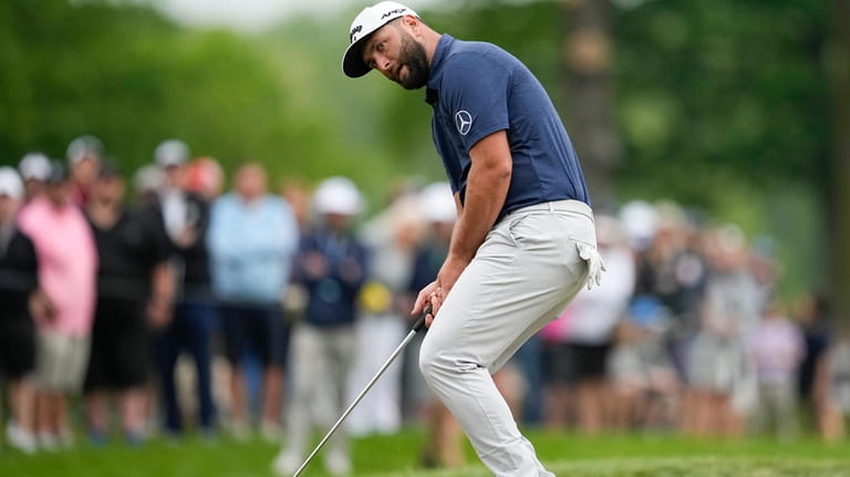 Jon Rahm, of Spain, reacts after missing a putt on...
