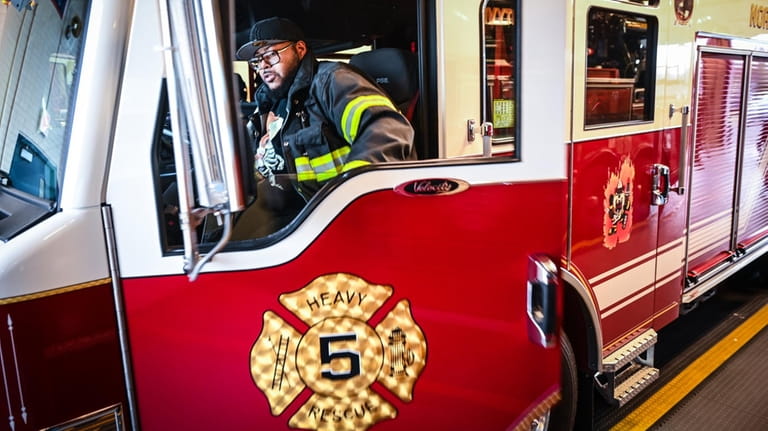 North Amityville firefighter Darnell McAuley performs a truck check in the truck...