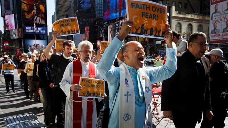A group of people representing multiple religious faiths gather to...