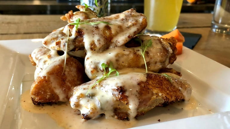 The wings at Social Gastropub in Old Bethpage are tossed...