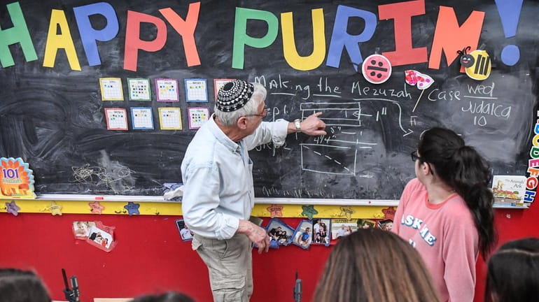 Teacher Nathan Litman uses the chalkboard to help explain how to...