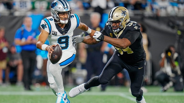 Carolina Panthers quarterback Bryce Young looks to pass under pressure...