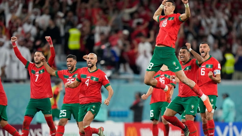 Morocco's Jawad El Yamiq, top, celebrates with team mates after...