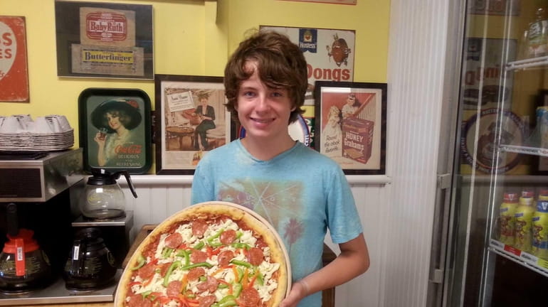 Thirteen-year-old Andy Mosolino makes "take-and-bake" pizzas at The Deli Counter...