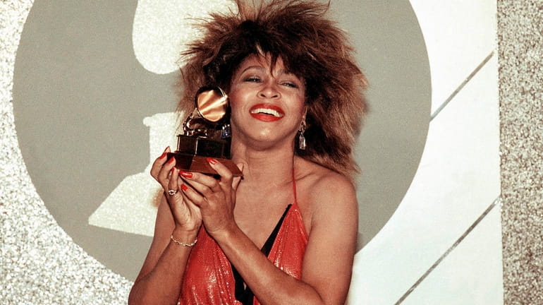 Tina Turner, Pop and R&B vocalist, as holds up a...