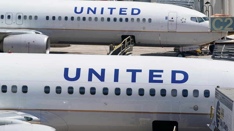 Two United Airlines Boeing 737s are parked at the gate...
