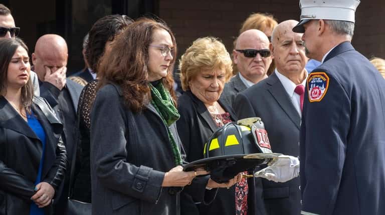 Ellen Gallagher is presented a helmet after the coffin holding...