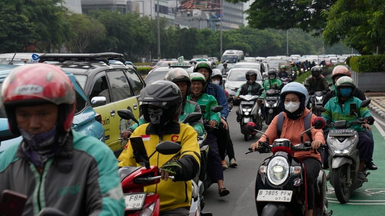 Motorist make their way through morning traffic in Jakarta, Indonesia,...